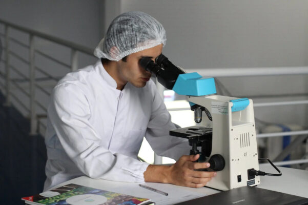 Researcher working in lab looking through a microscope