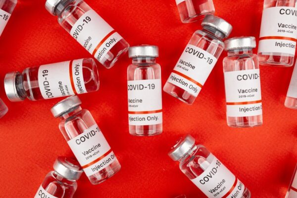 Covid-19 vaccine bottles on red background