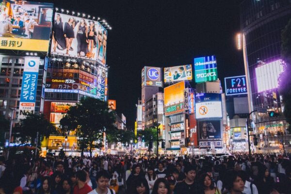 A Japanese city square full of people at night