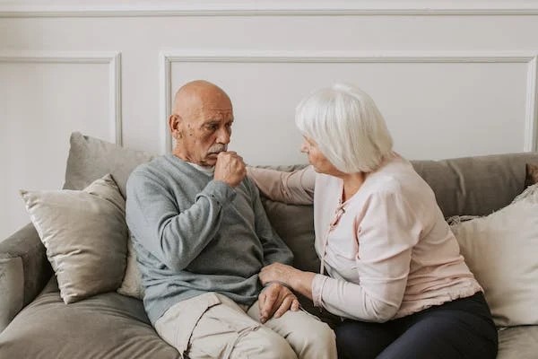 A woman taking care of a coughing man