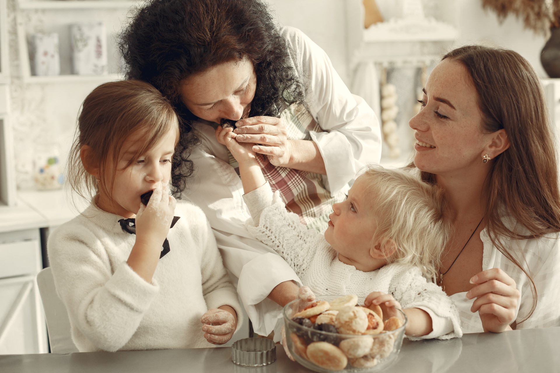 Grandmother, Mother and Two Little Girls in a Kitchen Eating Cookies