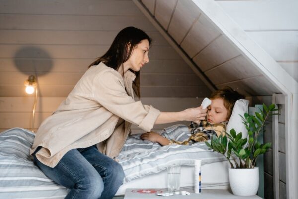 A mother taking care of her sick child with flu medication