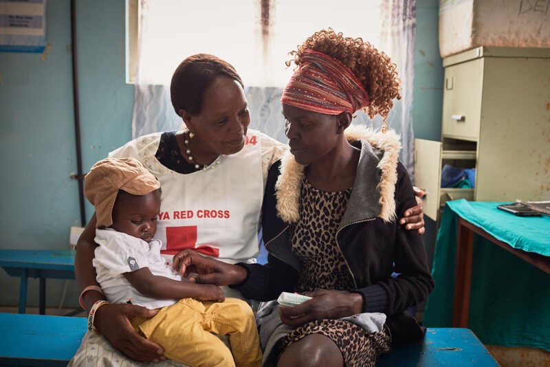 A health worker providing routine immunisation services to families in Kenya. Photo: Measles & Rubella Partnership.