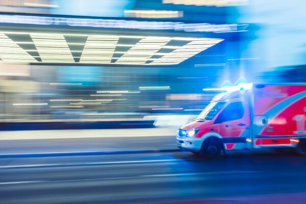 Red ambulance with lights in timelapse photography
