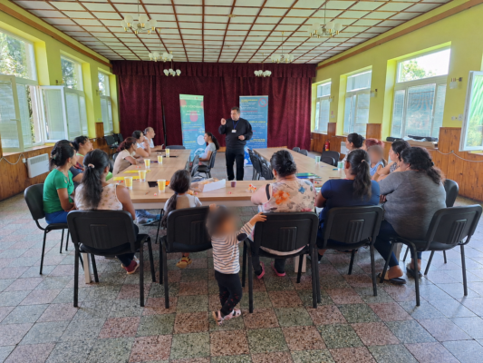 A Roma health mediator delivers an educational session to a group of people.